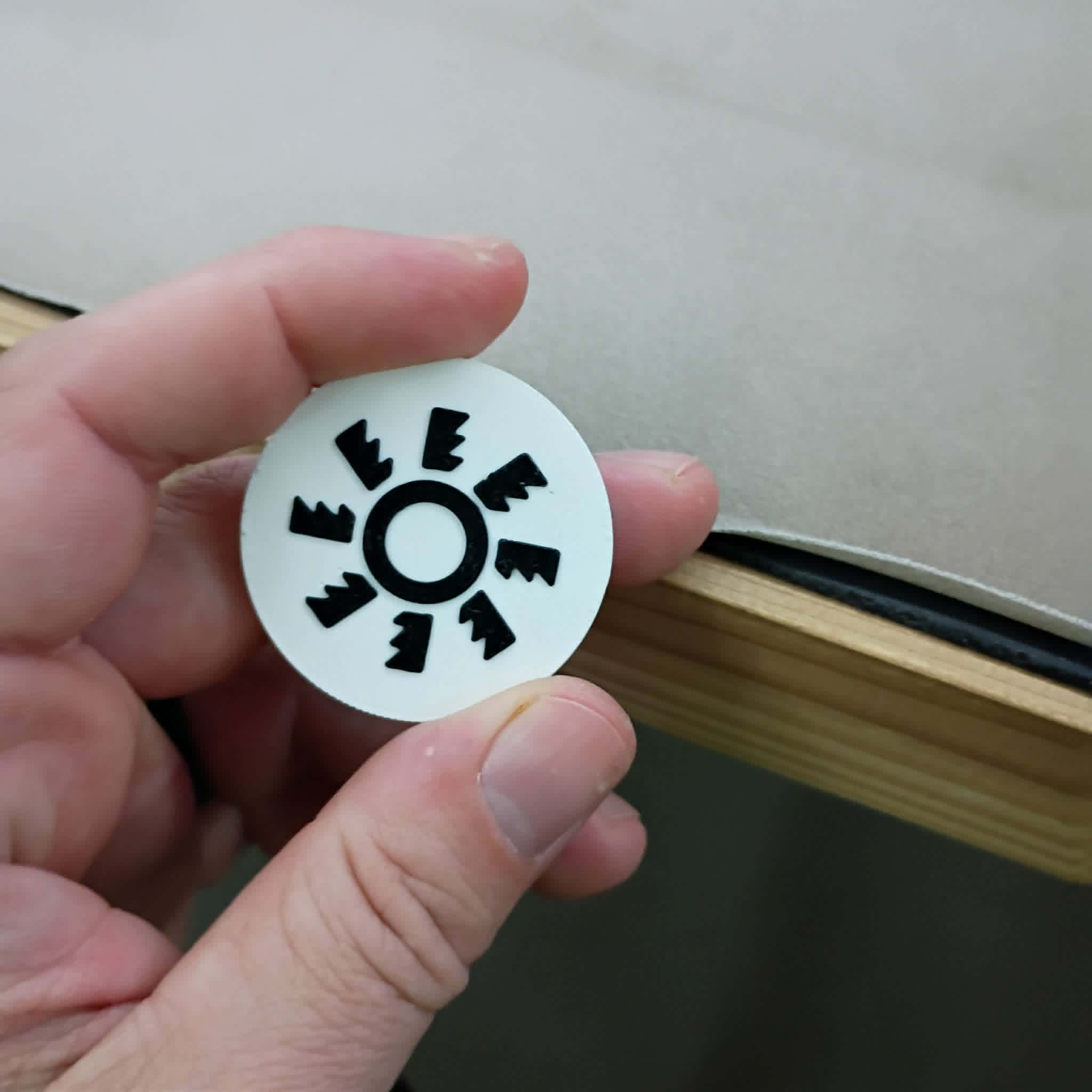 Hand holding a custom 3D printed NFC prototype chip